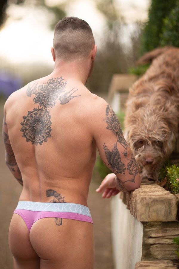 hombre tatuado en tanga