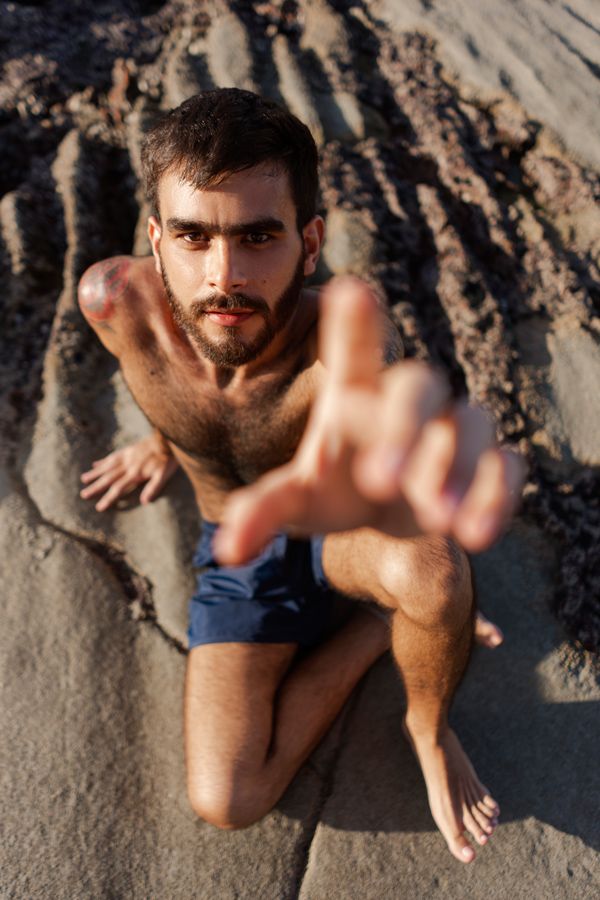 hombre guapo tomando el sol en la playa