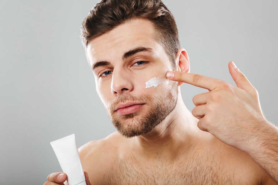 hombre aplicándose protección solar en la cara